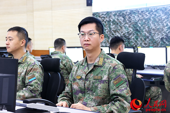 秦明（右一）在战区联合作战指挥中心研拟方案计划。张先瑞 摄
