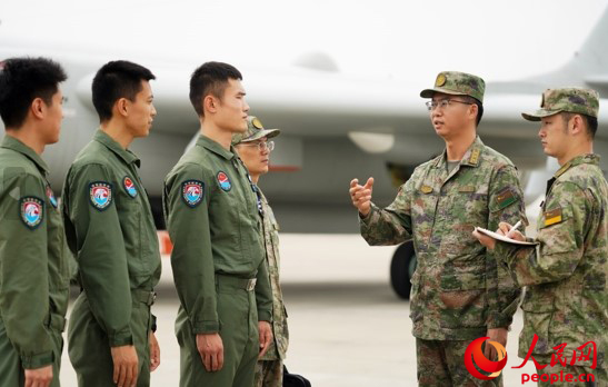 秦明在某机场与飞行人员探讨交流。任龙 摄