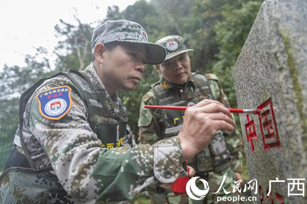 大新县第二巡边大队的护边员给界碑描红。人民网 雷琦竣摄