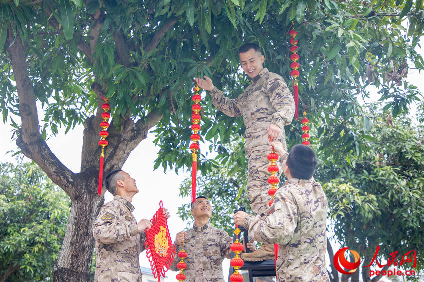 武警官兵在营区内挂灯笼。