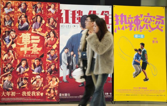 这是2月17日，在沈阳一家影院，观众从海报前经过。新华社记者李钢摄