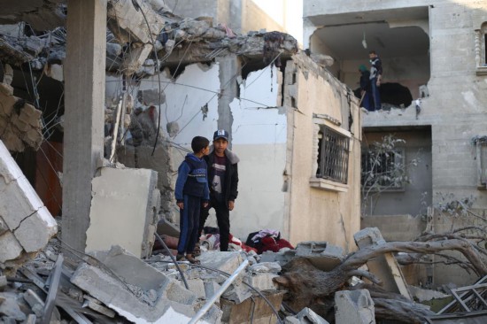 2月21日，在加沙地带南部城市拉法，巴勒斯坦人查看以军空袭后的废墟。新华社发（哈立德·奥马尔摄）