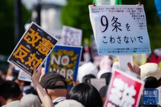 当地时间4月19日，人们在位于日本东京的国会议事堂周围参加抗议活动，呼吁守护和平宪法。图源：新华社
